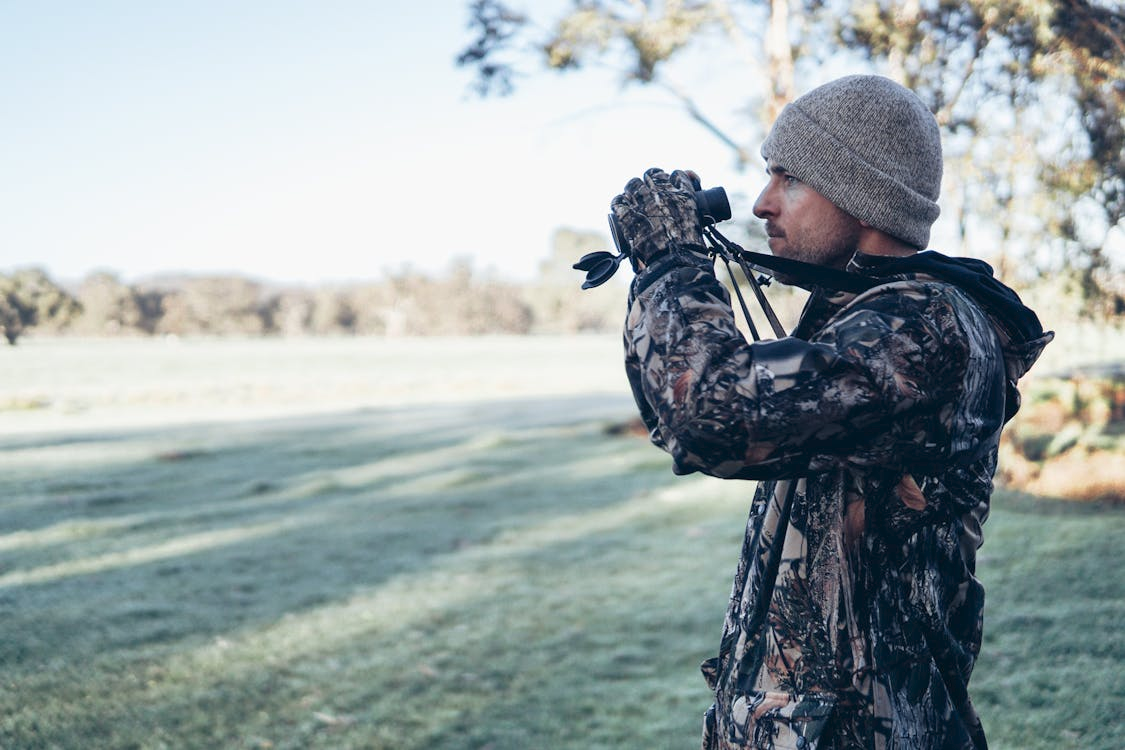 Investigator observing a subject through binoculars during a surveillance operation