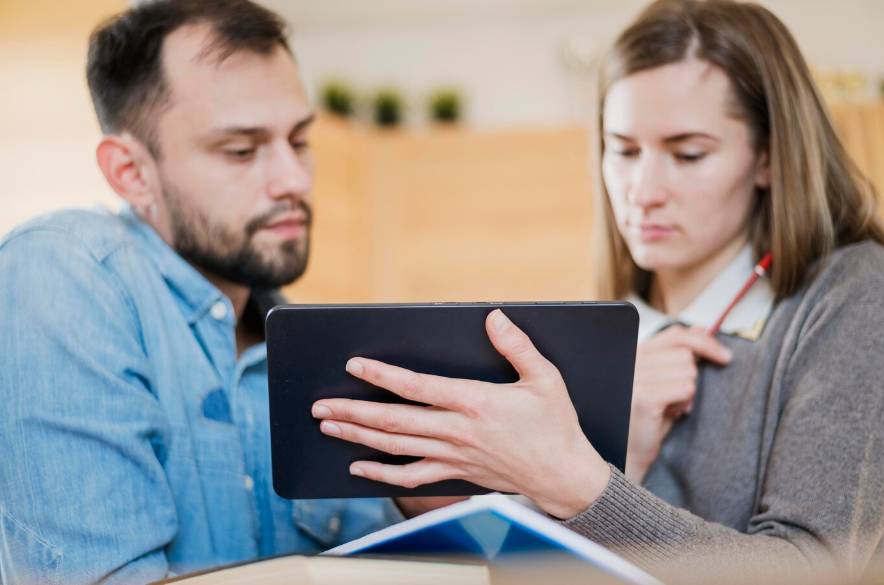 a man and woman using a tablet