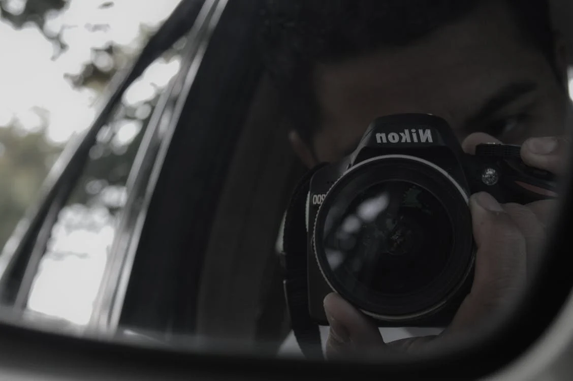 A private investigator conducting surveillance with a camera