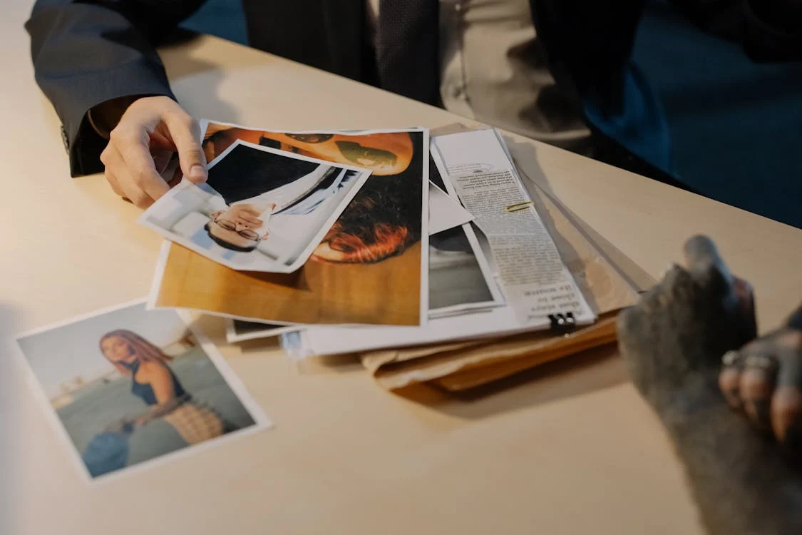 A private investigator reviewing legal documents and photographs.